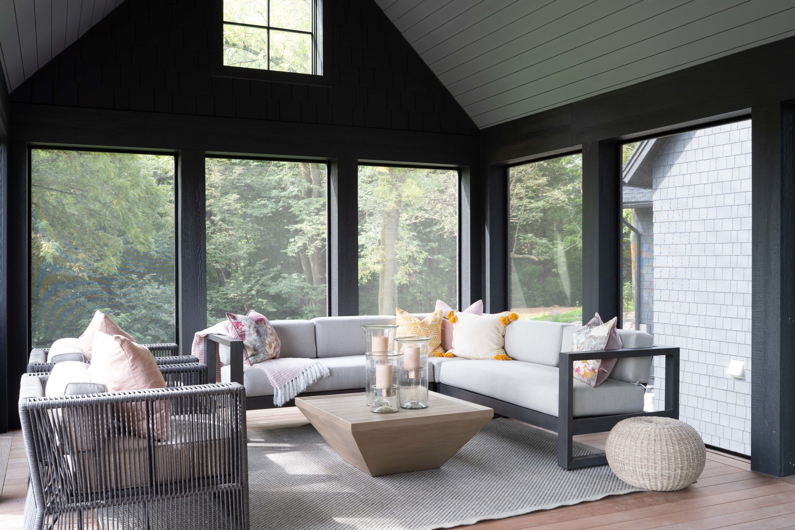 A sunroom with black furniture.