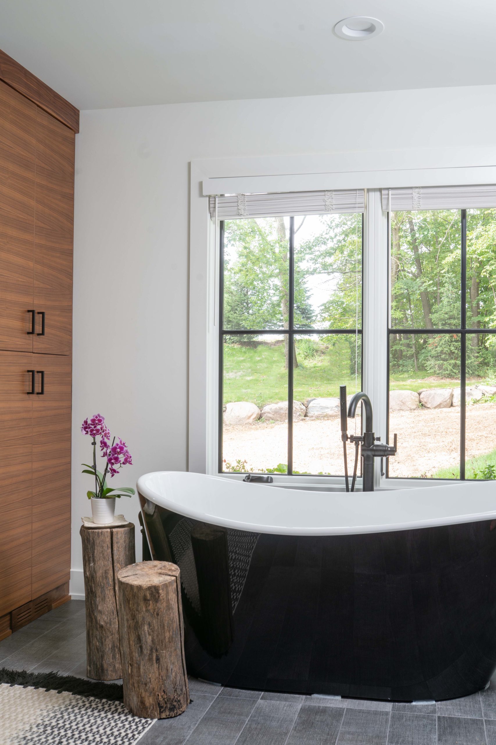 A bathroom with a black tub and a window, featured in the Kitchens portfolio.