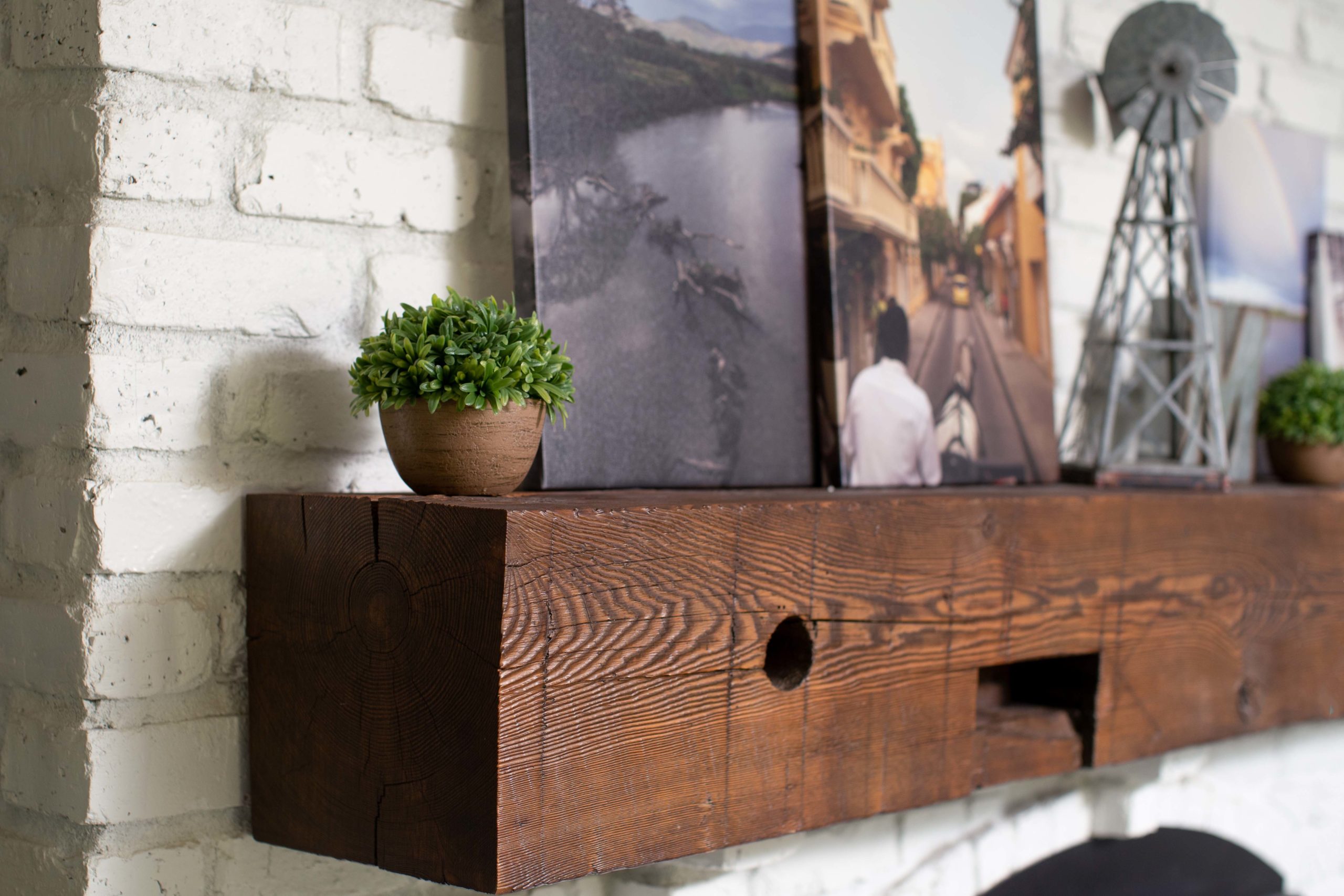 A wooden mantle displaying a portfolio of pictures in the kitchen.