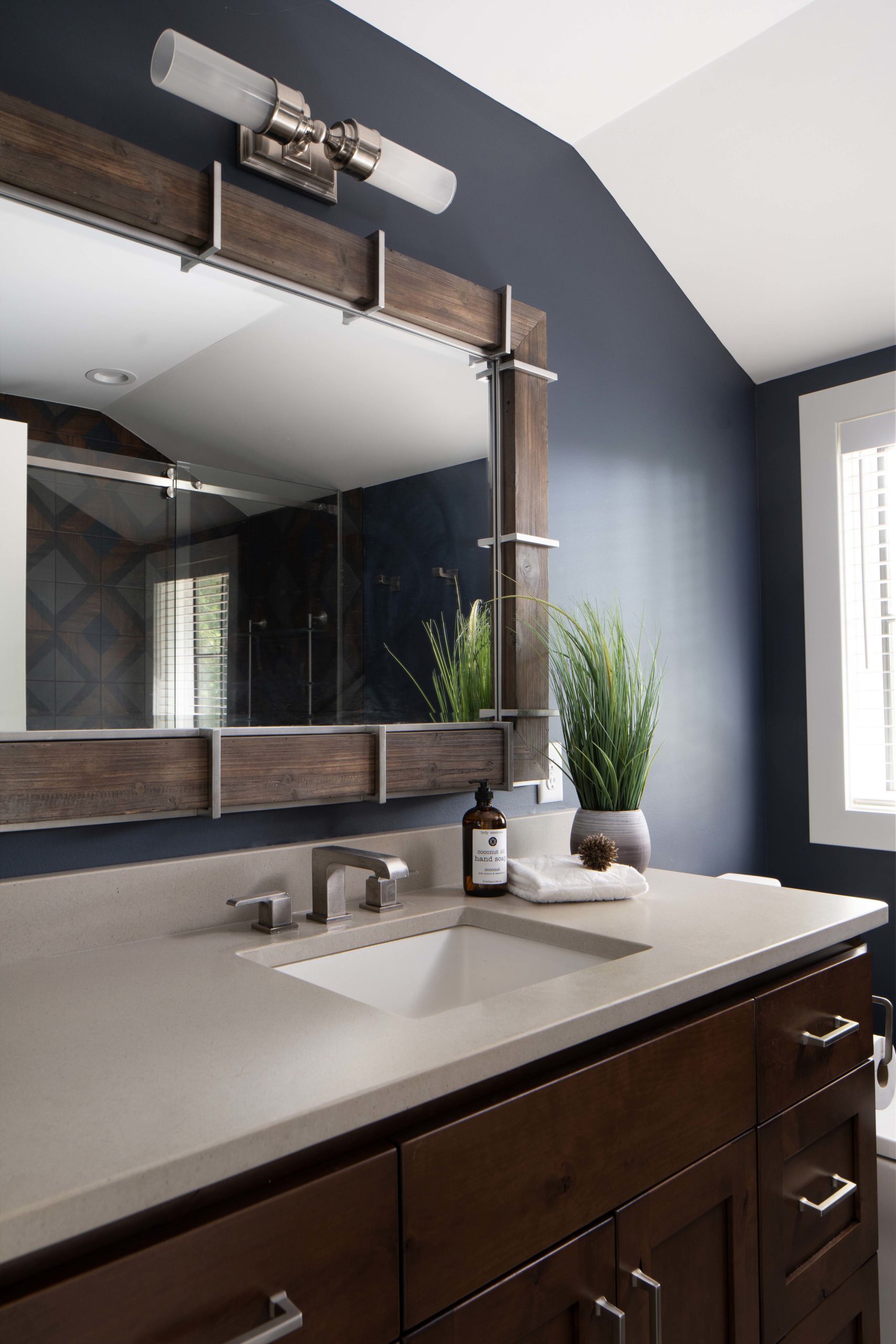 A bathroom with blue walls and a wooden vanity.