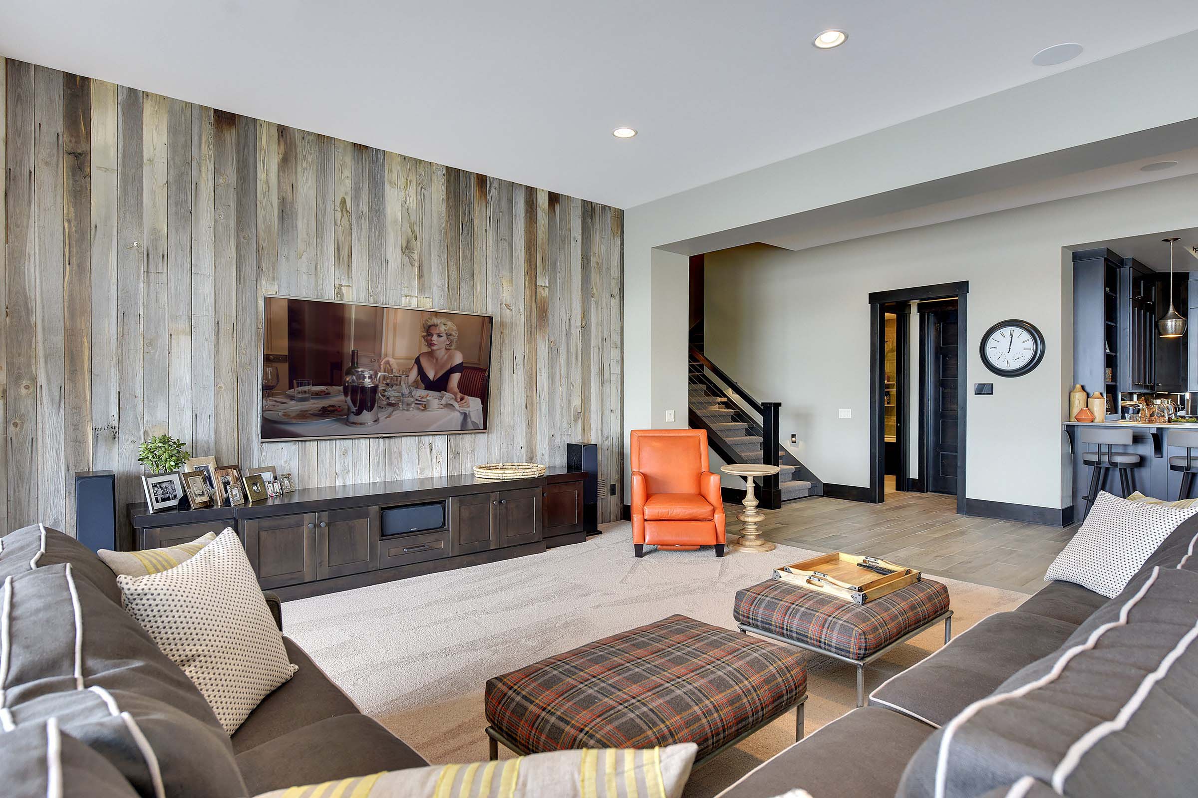 A living room with wood paneling and a flat screen tv, featured in our portfolio.