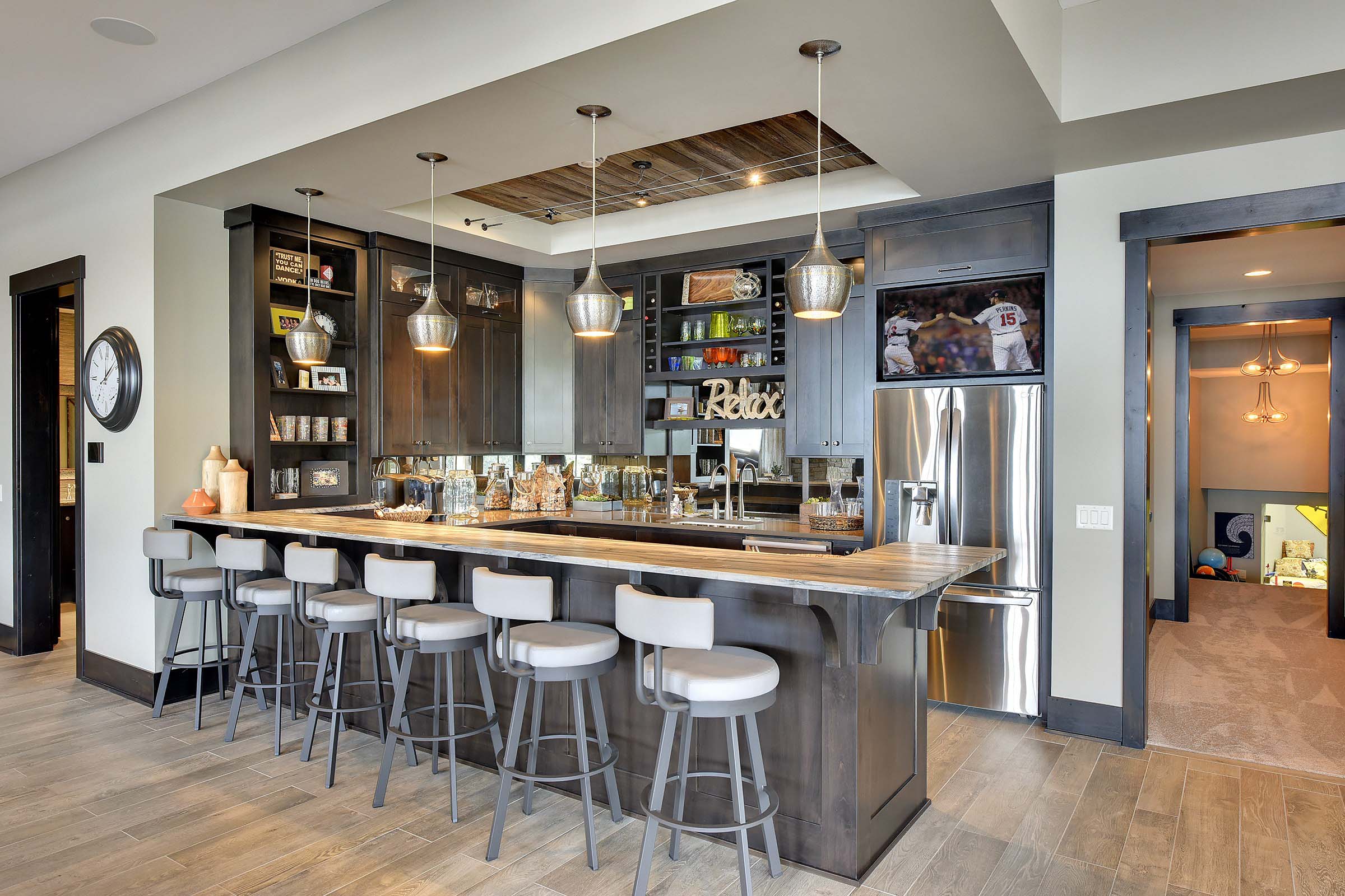 A home bar with stools and a television, featured in our Kitchens portfolio.