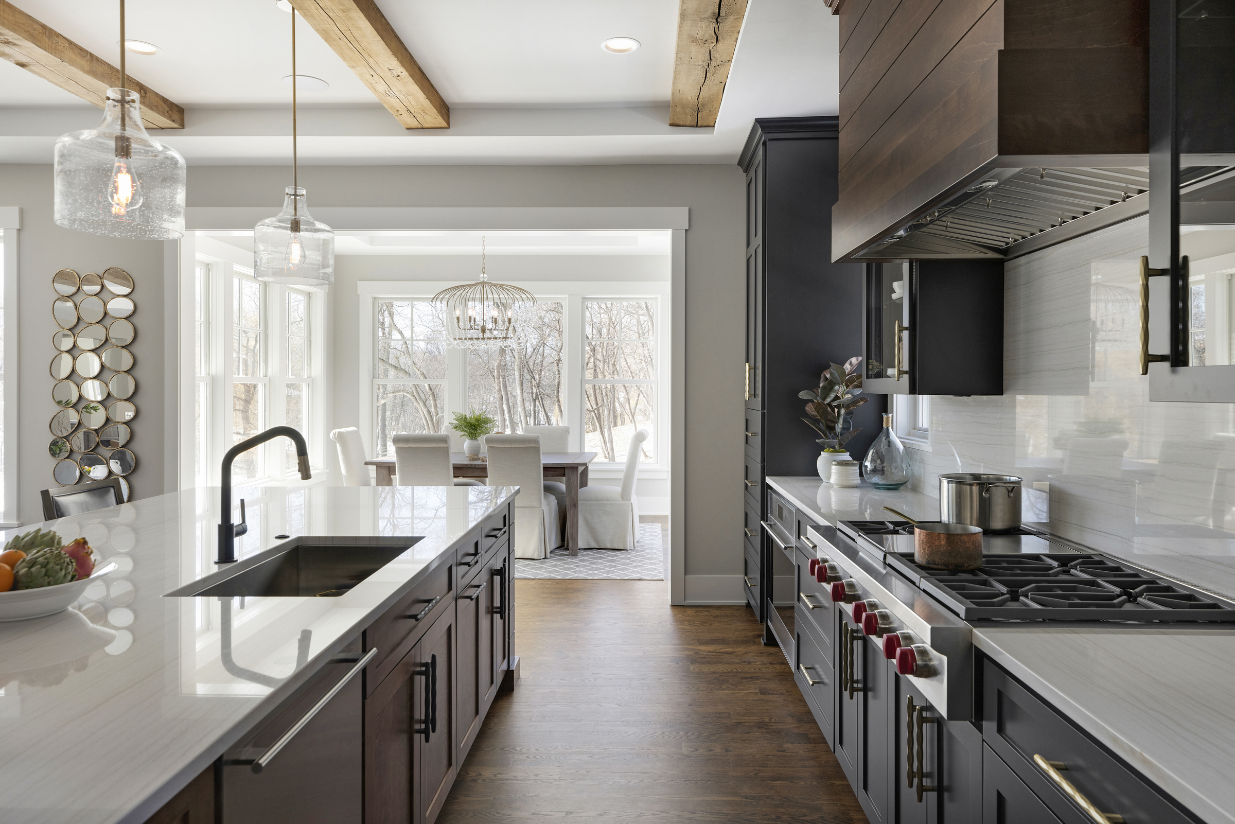 kitchen with black upper cabinets, brown lower cabinets, an oversized island with white countertops