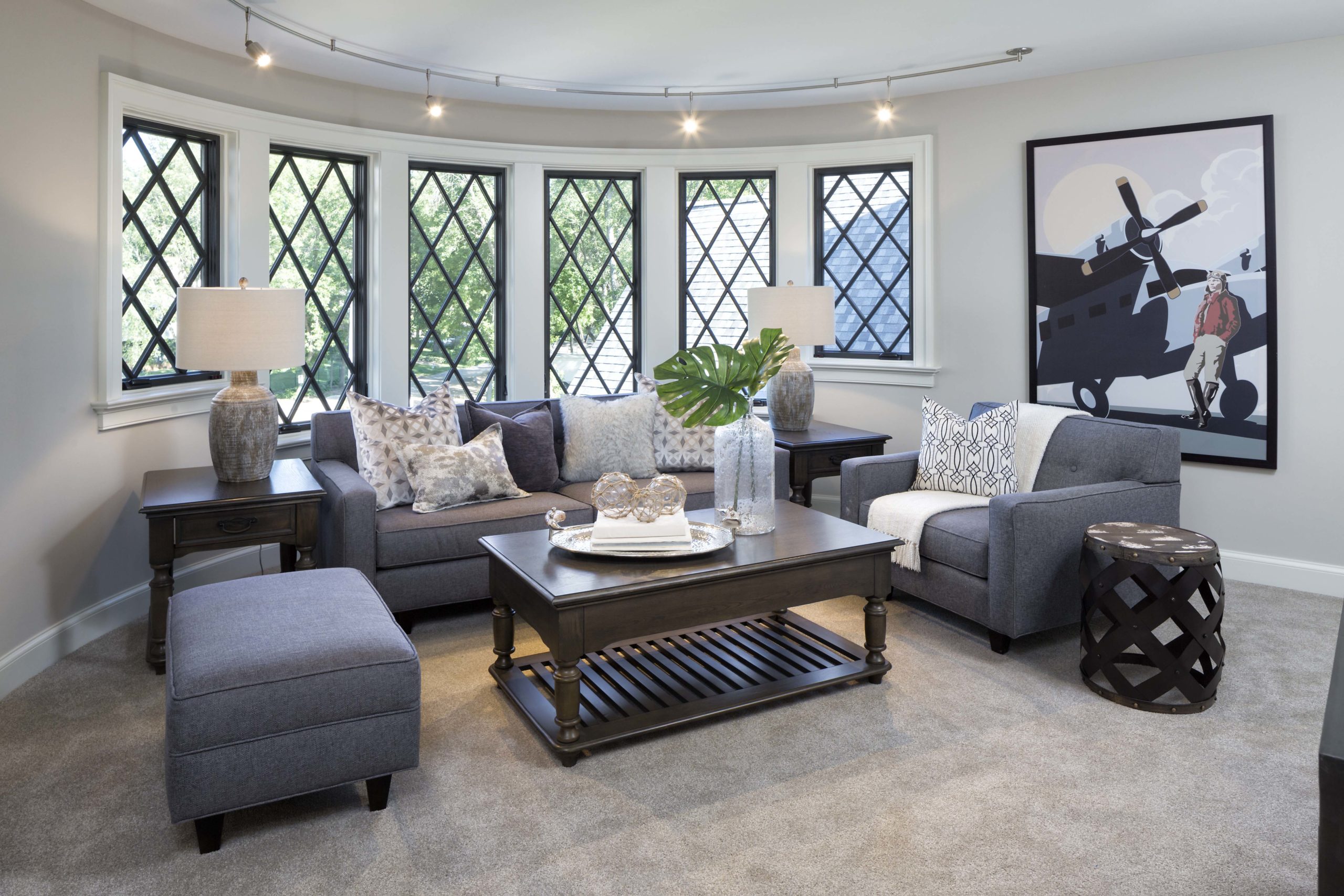 living room with diamond grilled window panes and a large grey sectional couch in the room