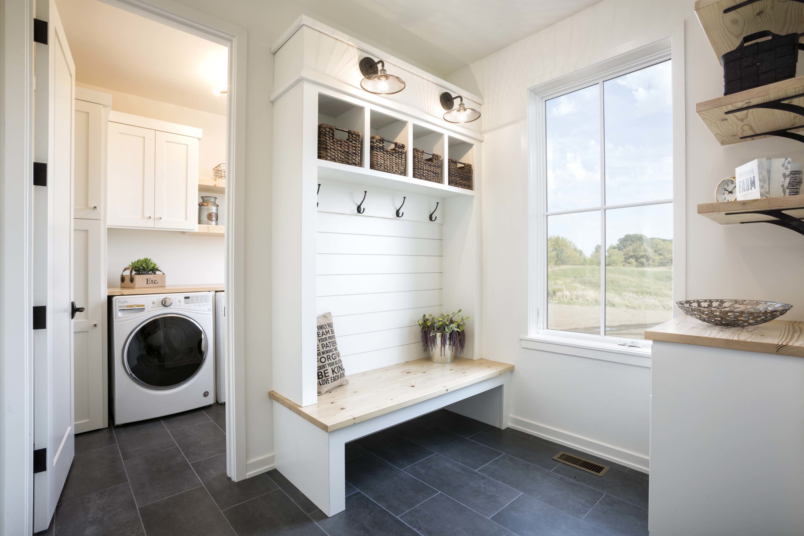 A farmhouse laundry room in Lakeville, Minnesota with a bench and washer and dryer.