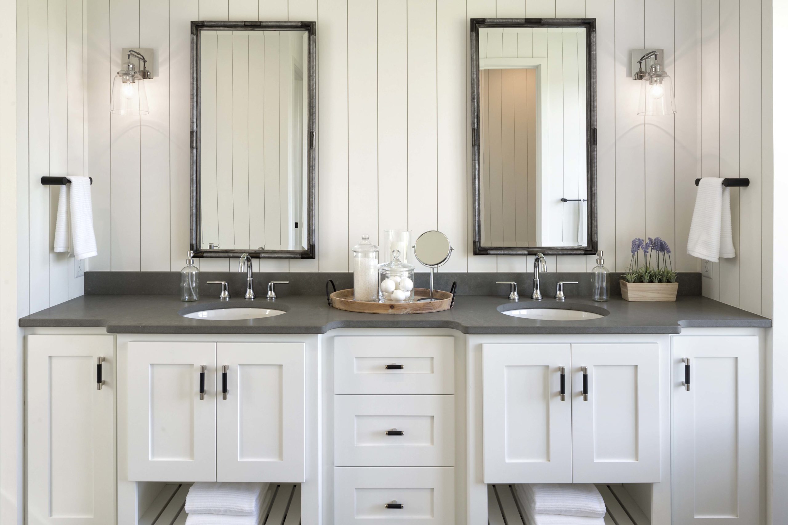 A white bathroom with two sinks and mirrors, located in Reverence Farmhouse in Lakeville, Minnesota.