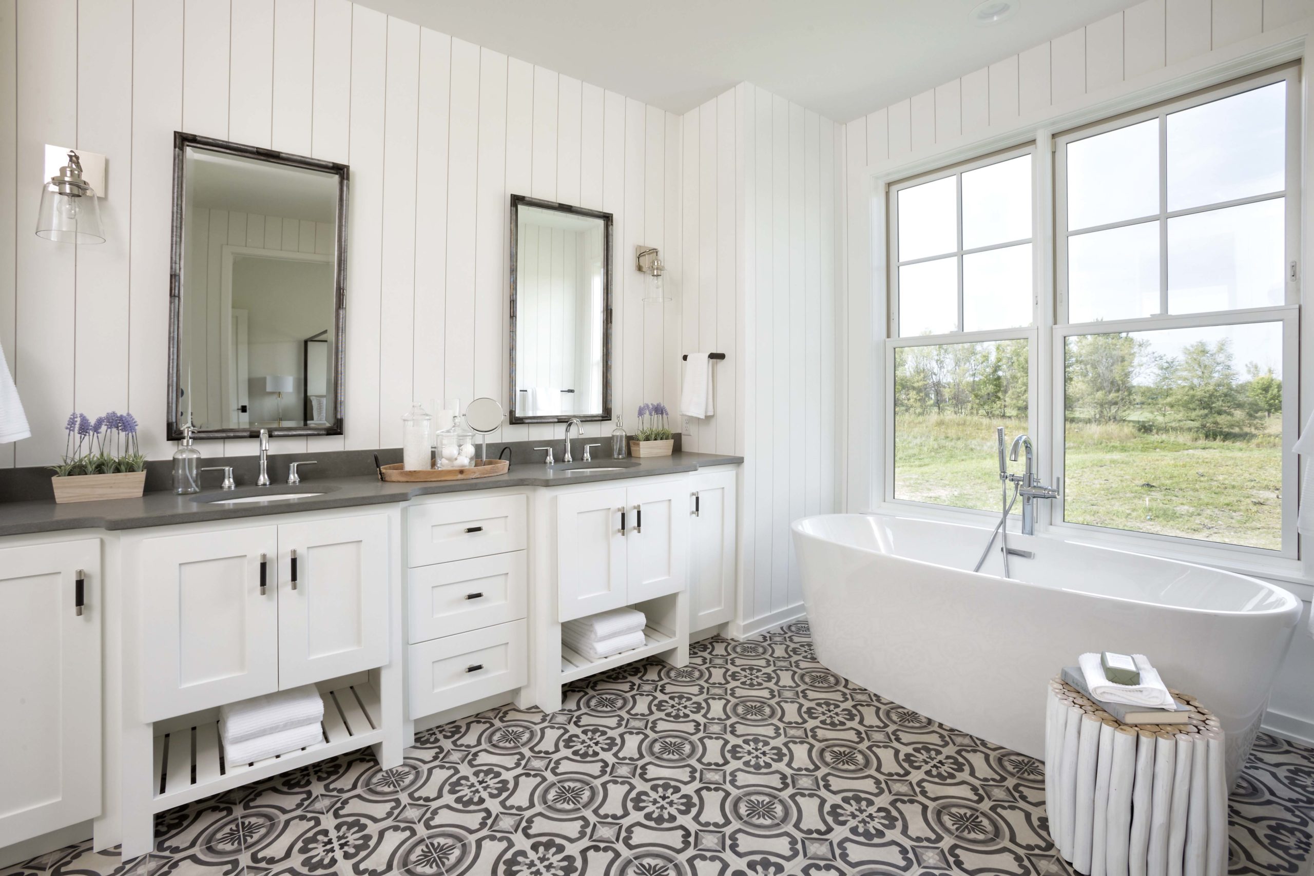 master bathroom with dual vanities and patterned tile floors
