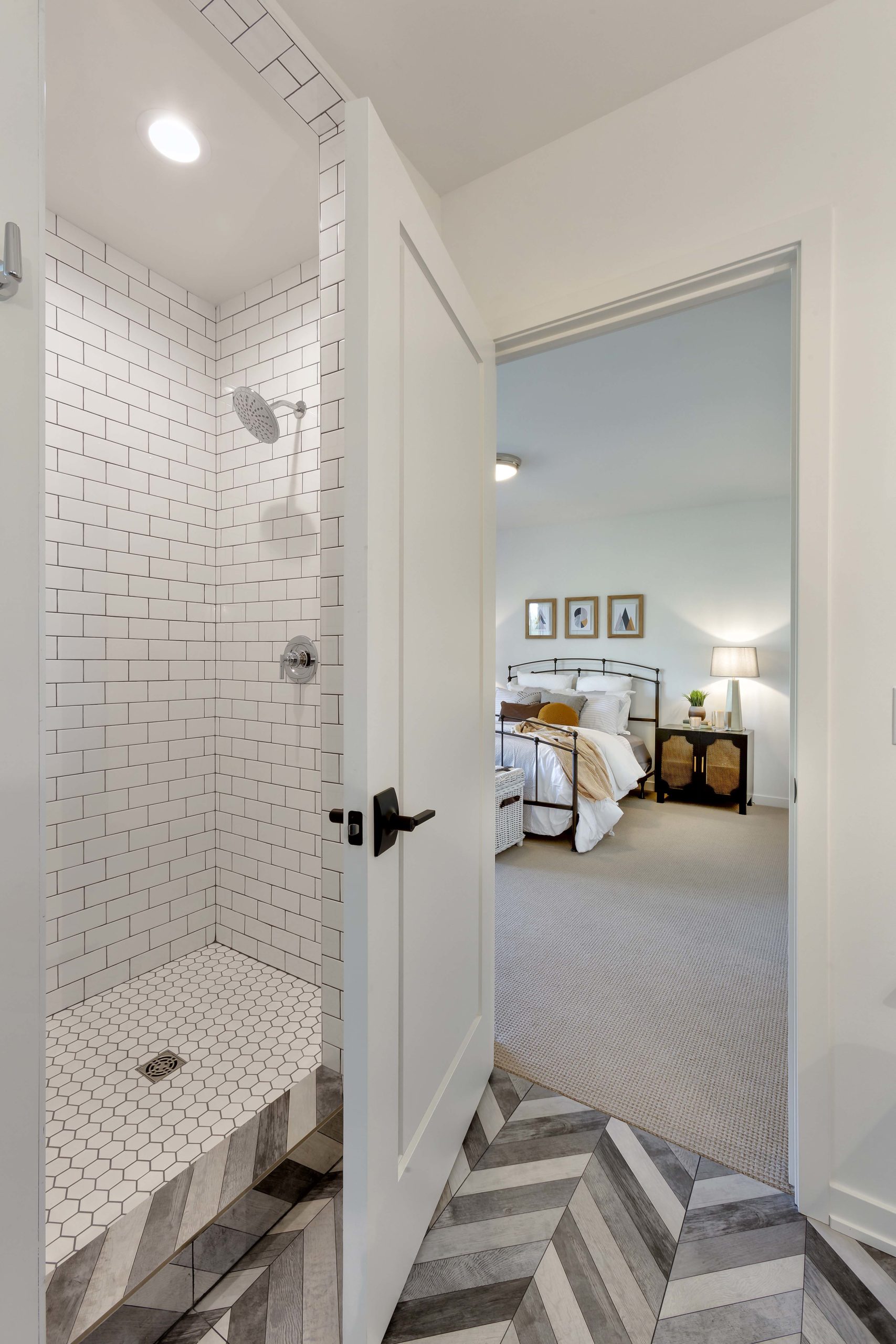 grey chevron floors and white subway tile shower in bathroom