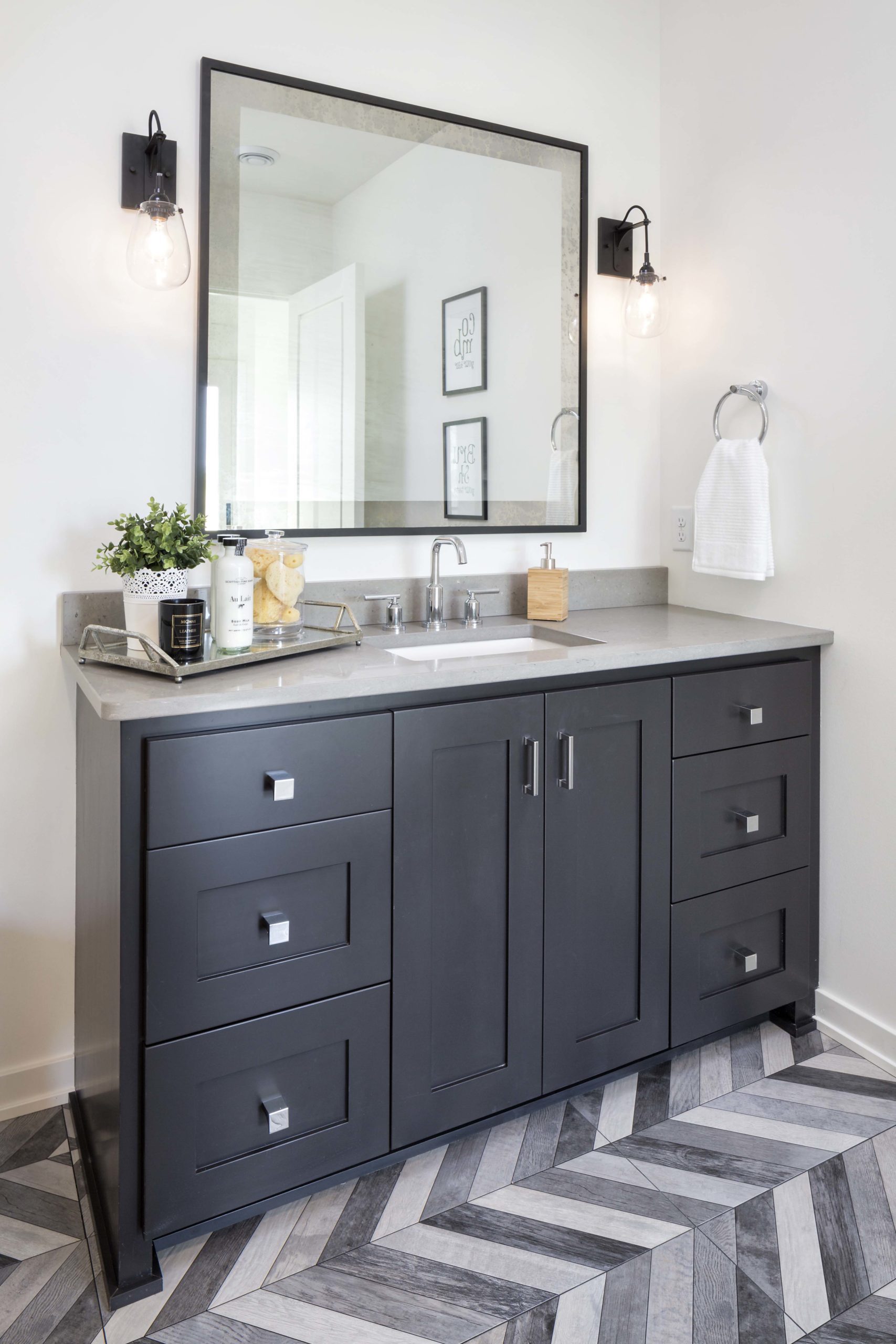 A black and white bathroom with a chevron floor in Reverence's farmhouse design located in Lakeville, Minnesota.