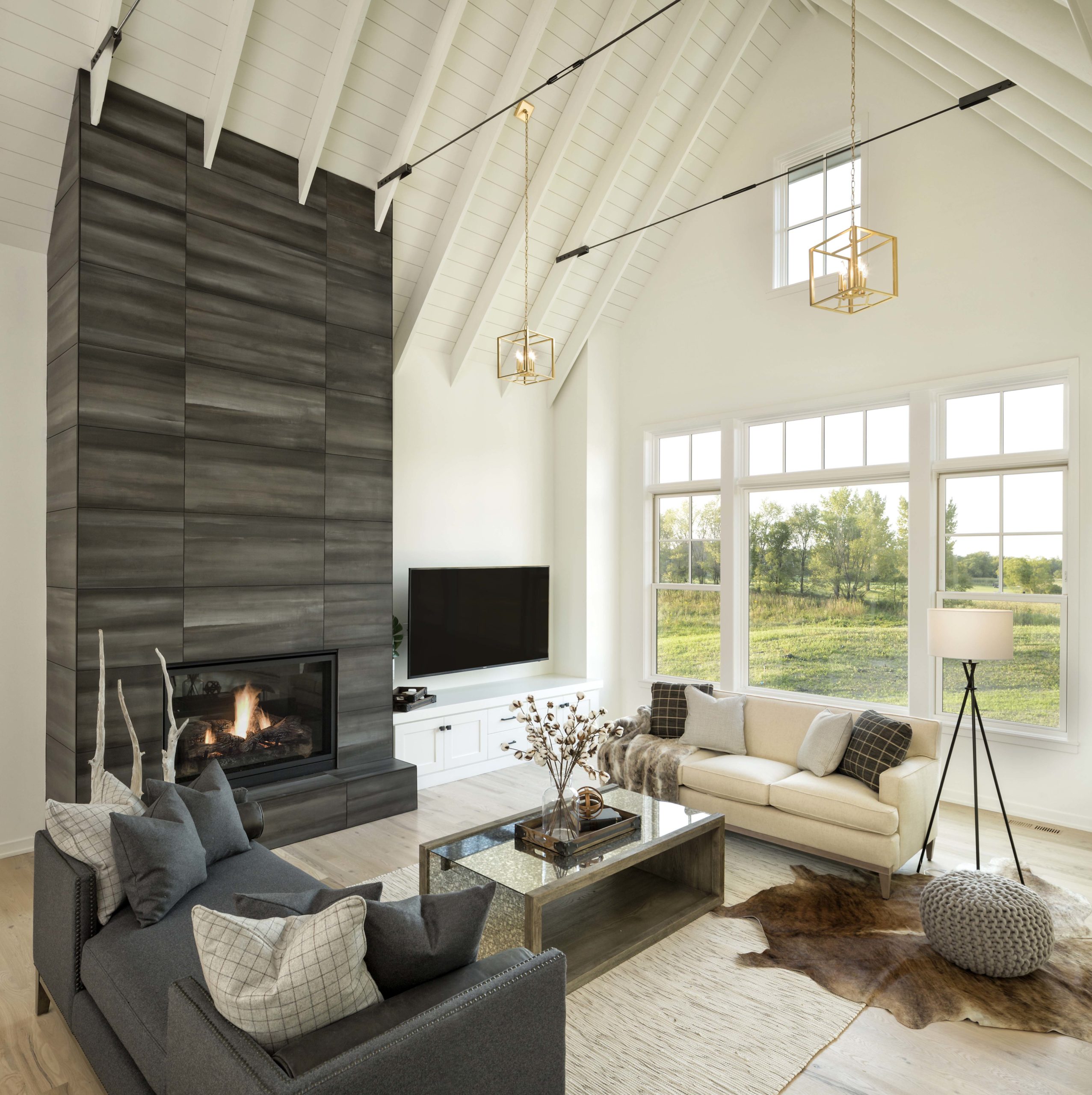 modern farmhouse style living room with white shiplap ceiling, large fireplace, and white couch