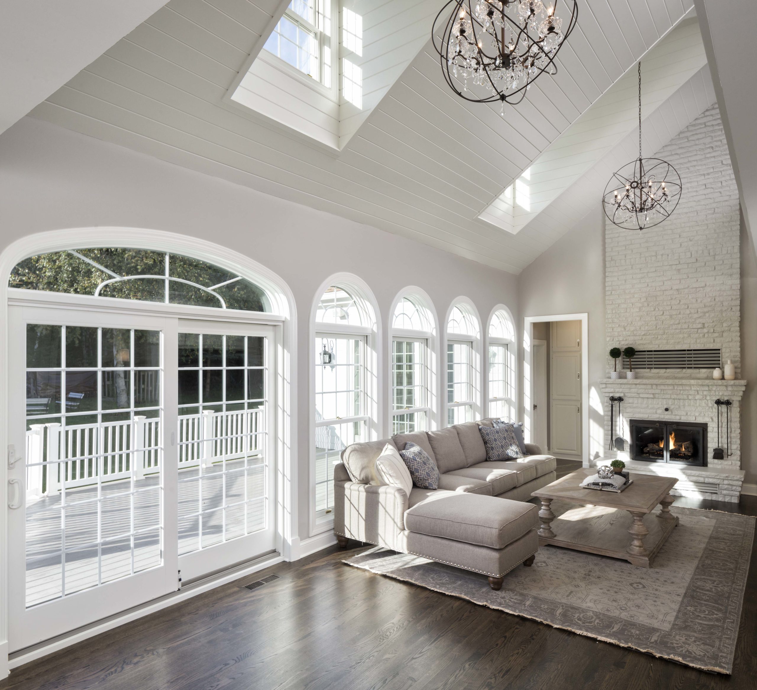 white living room with arched windows along the wall and a sectional sofa