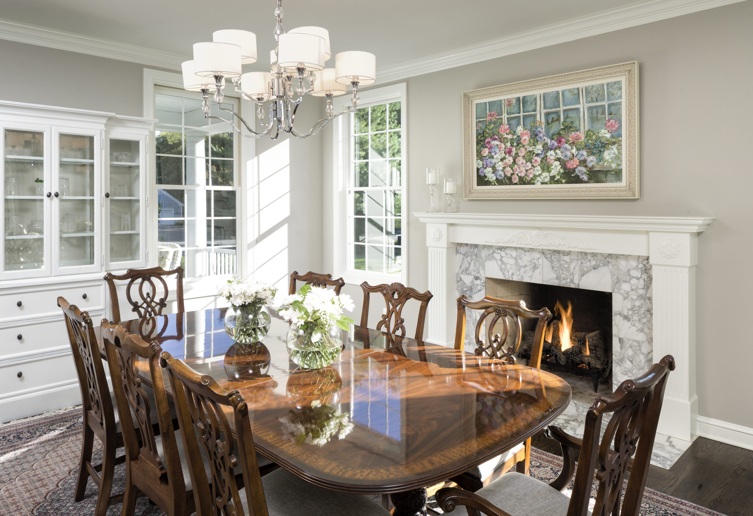 traditional dining room with wooden table, fireplace, and white china cabinet