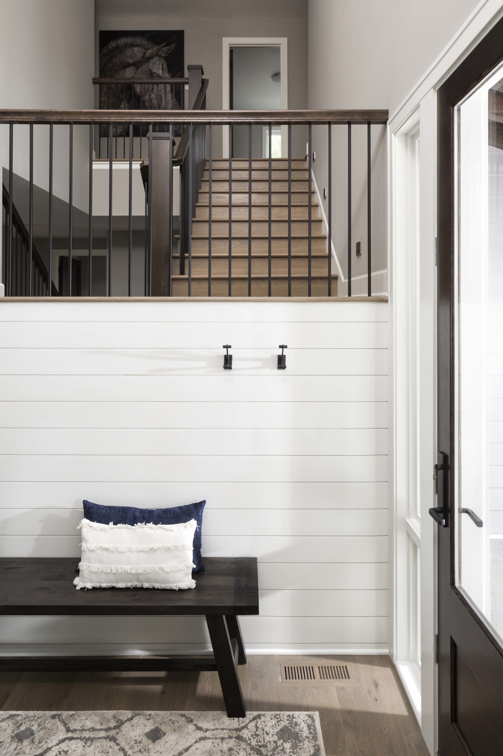 entryway with shiplap and a black bench