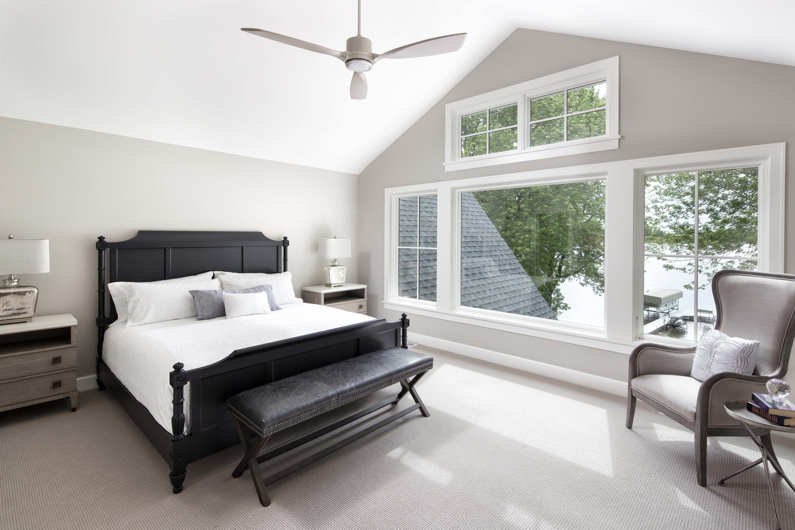 master bedroom with three large windows and a king size bed in the middle of the room