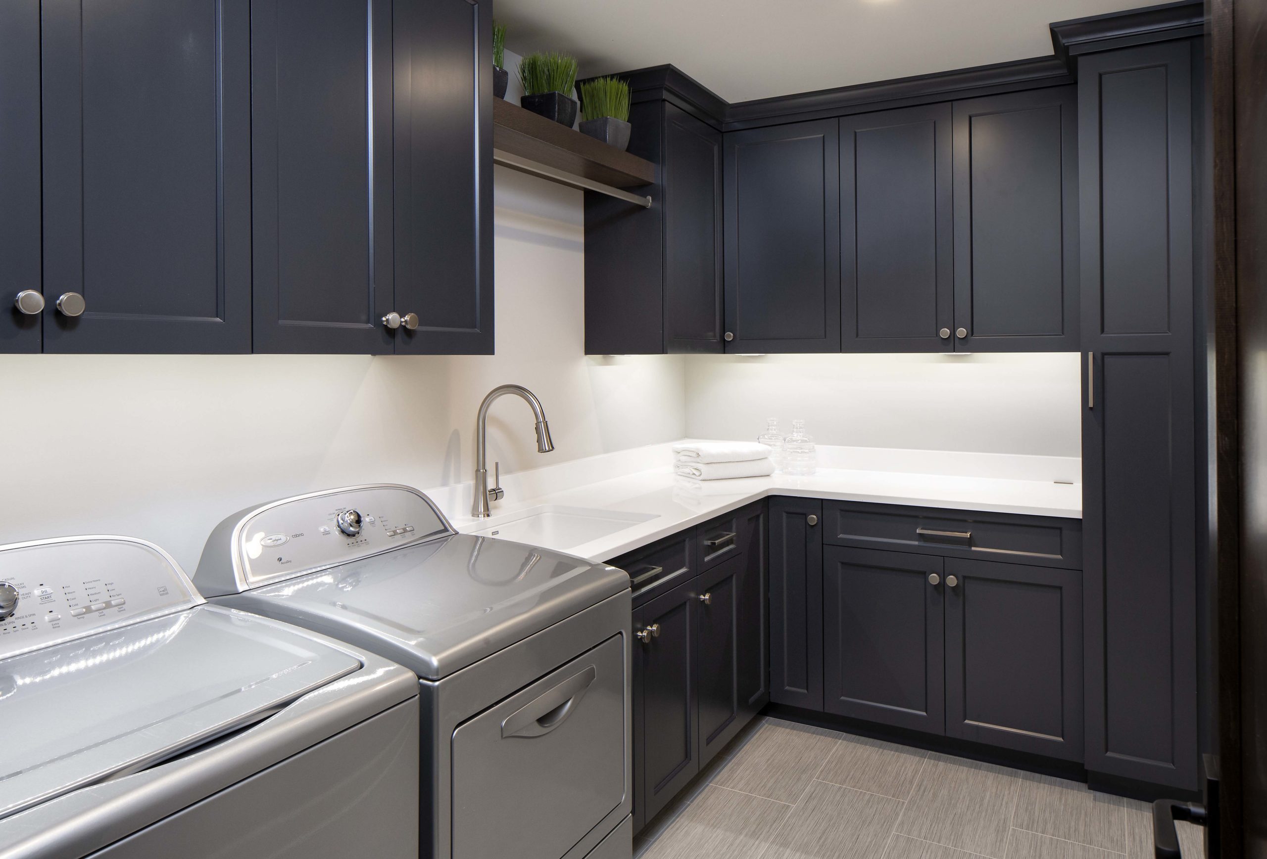 laundry room with dark blue painted cabinets and a washer and dryer