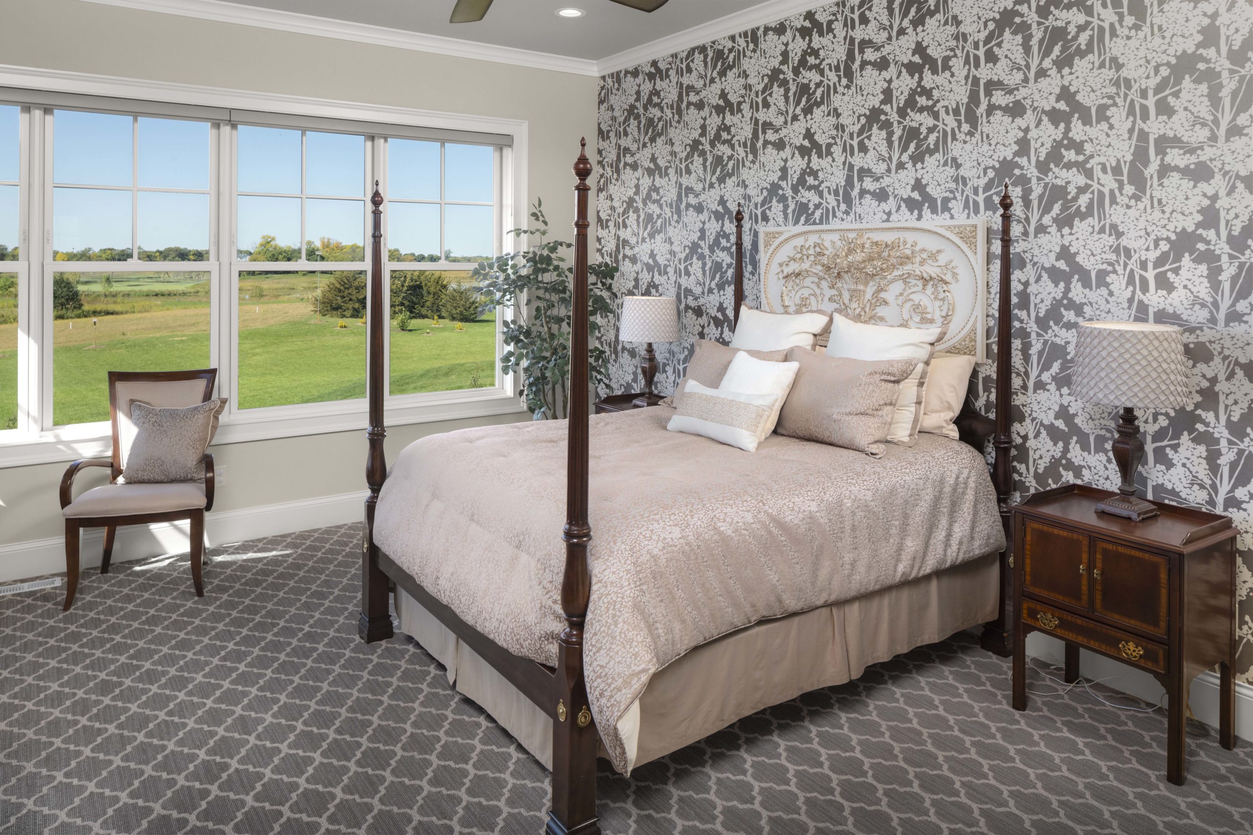 master bedroom with patterned wallpaper and a four post king sized bed