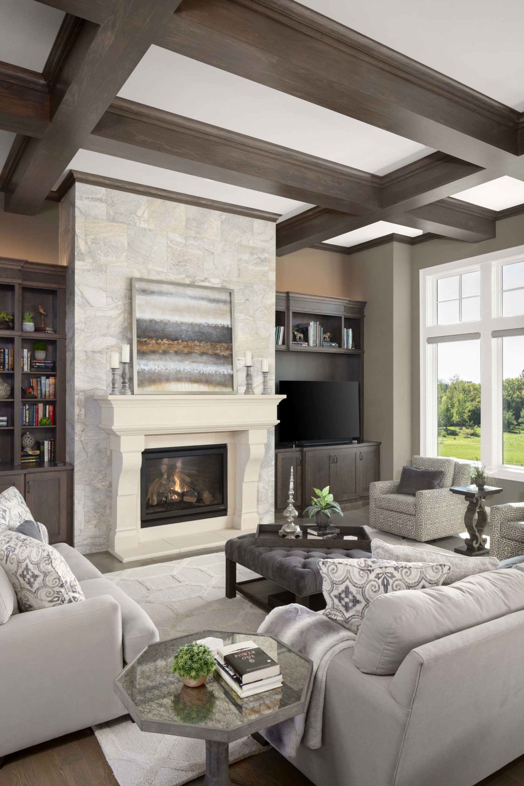 Great room with light stone fireplace surround and light grey furniture