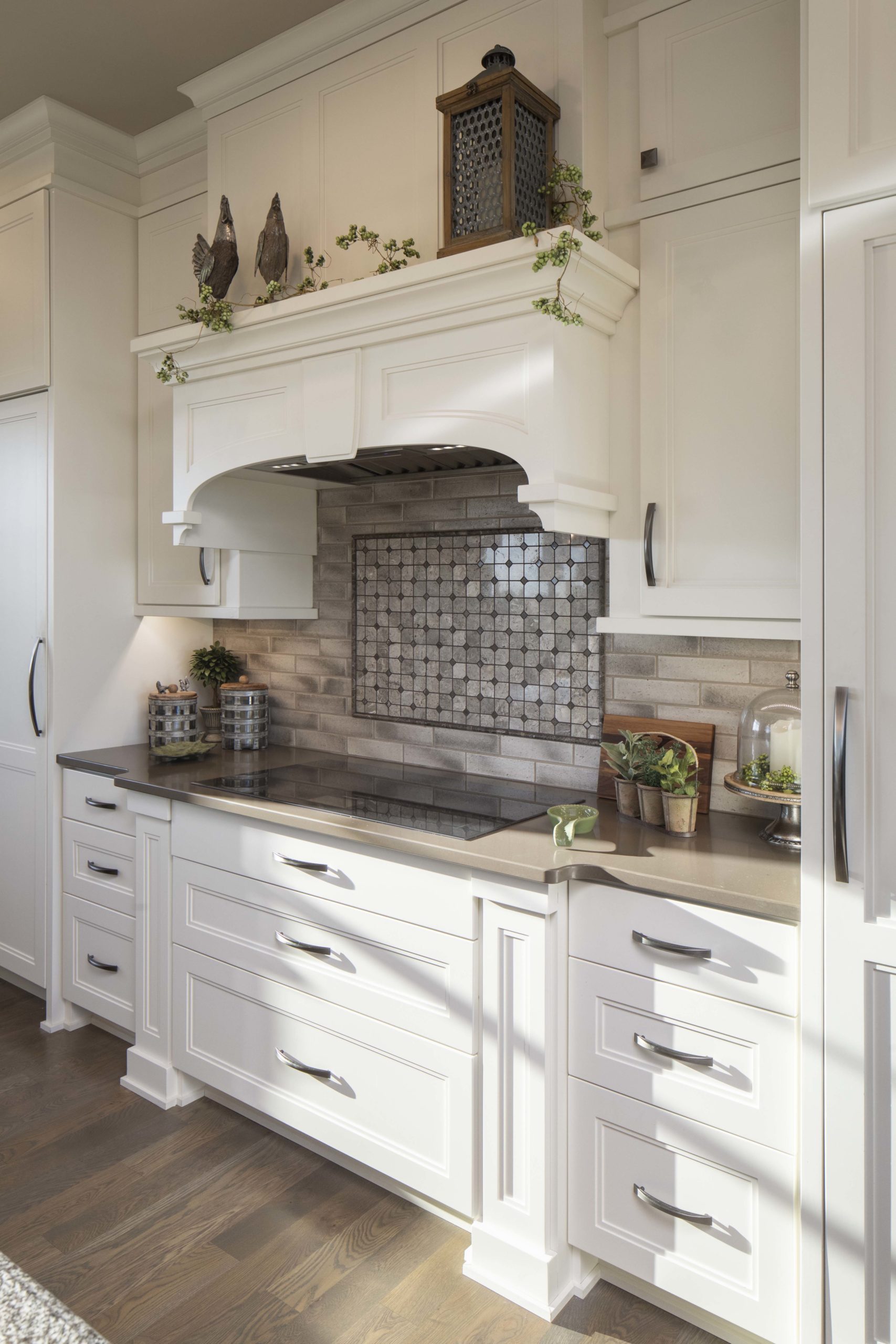 white cabinets in a kitchen with a tile backsplash behind the stove