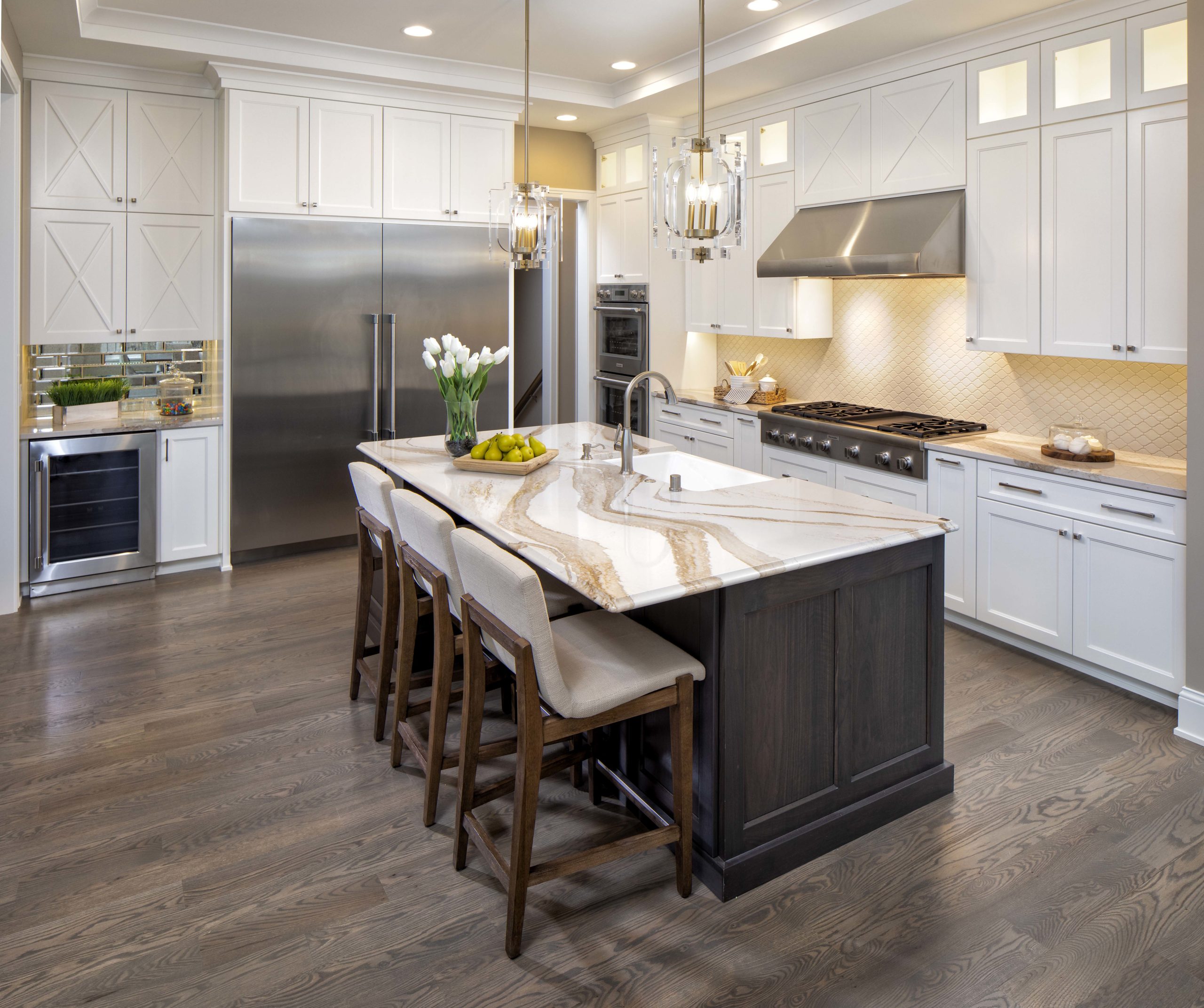 a kitchen with dark wood floors, white cabinets, a marbled countertop and three barstools