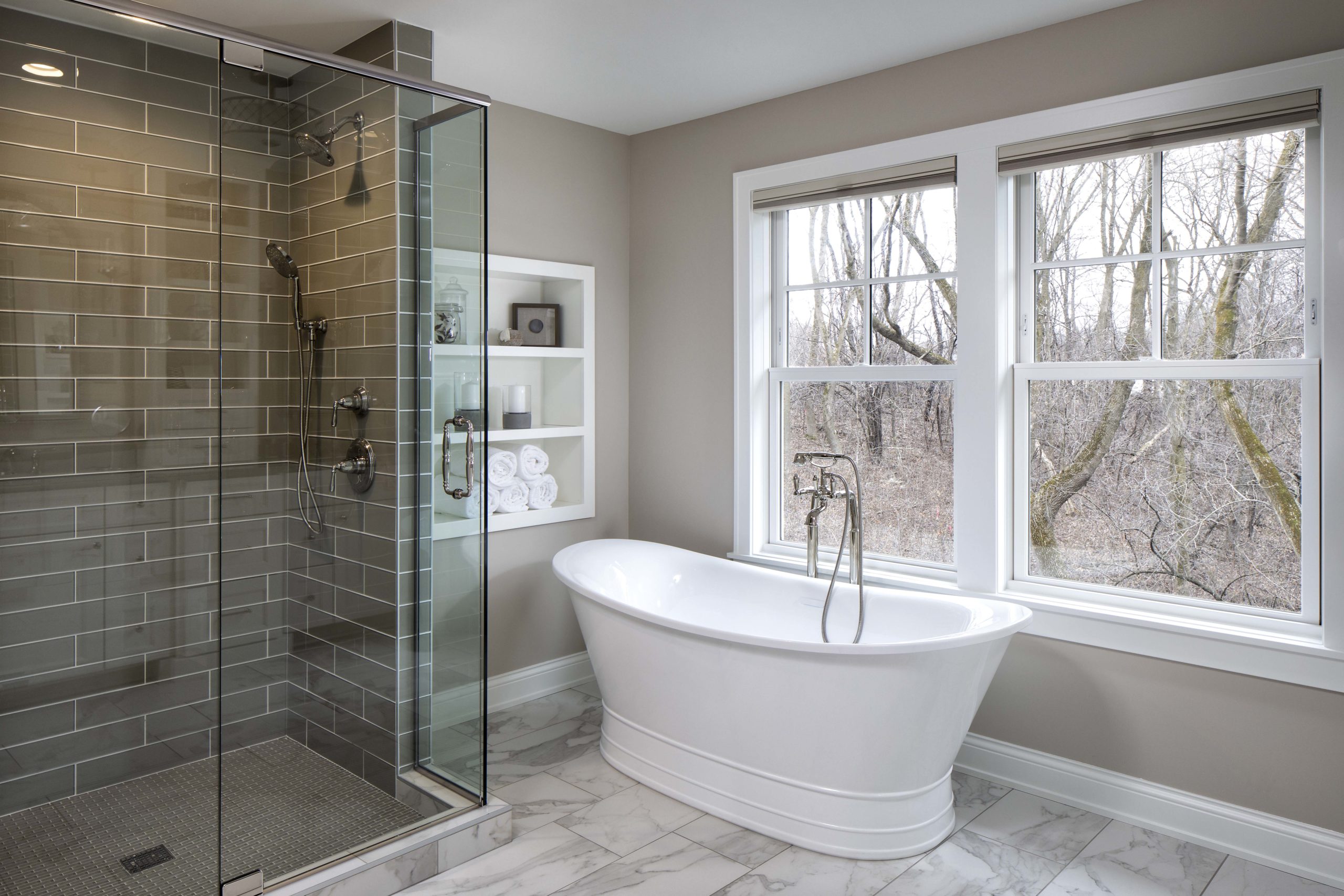 master bathroom with glass shower and white standing tub