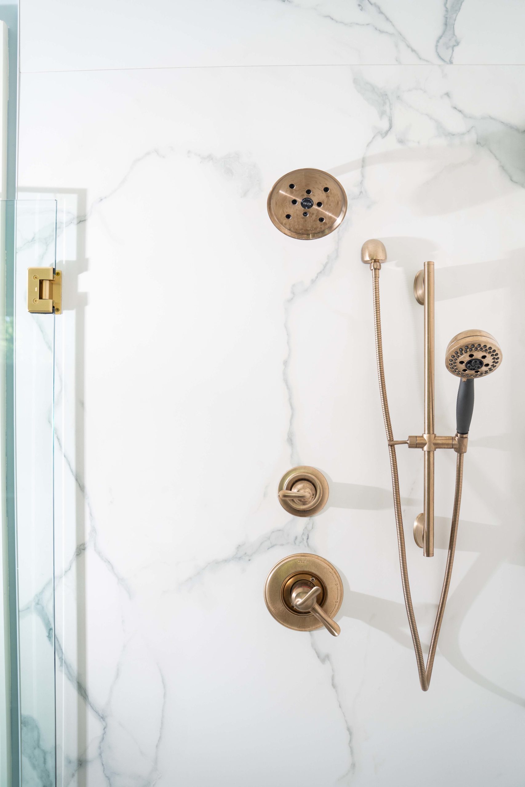 A bathroom with a brass shower head and faucet located on White Oak Lane.