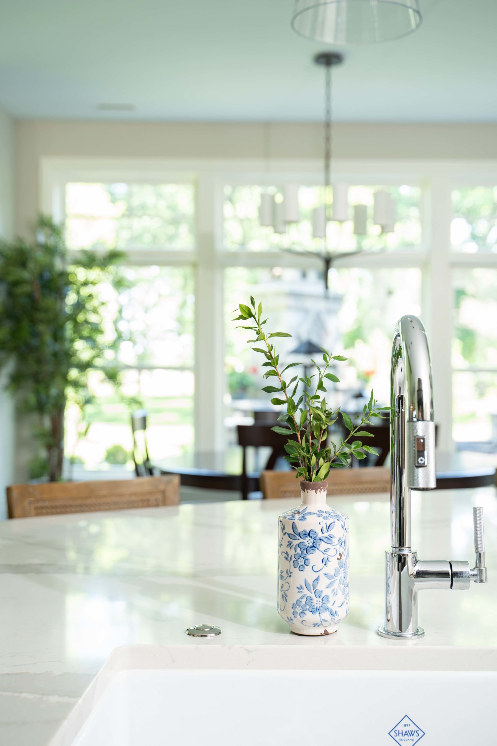 A white sink in a kitchen with a plant in it on White Oak Lane.