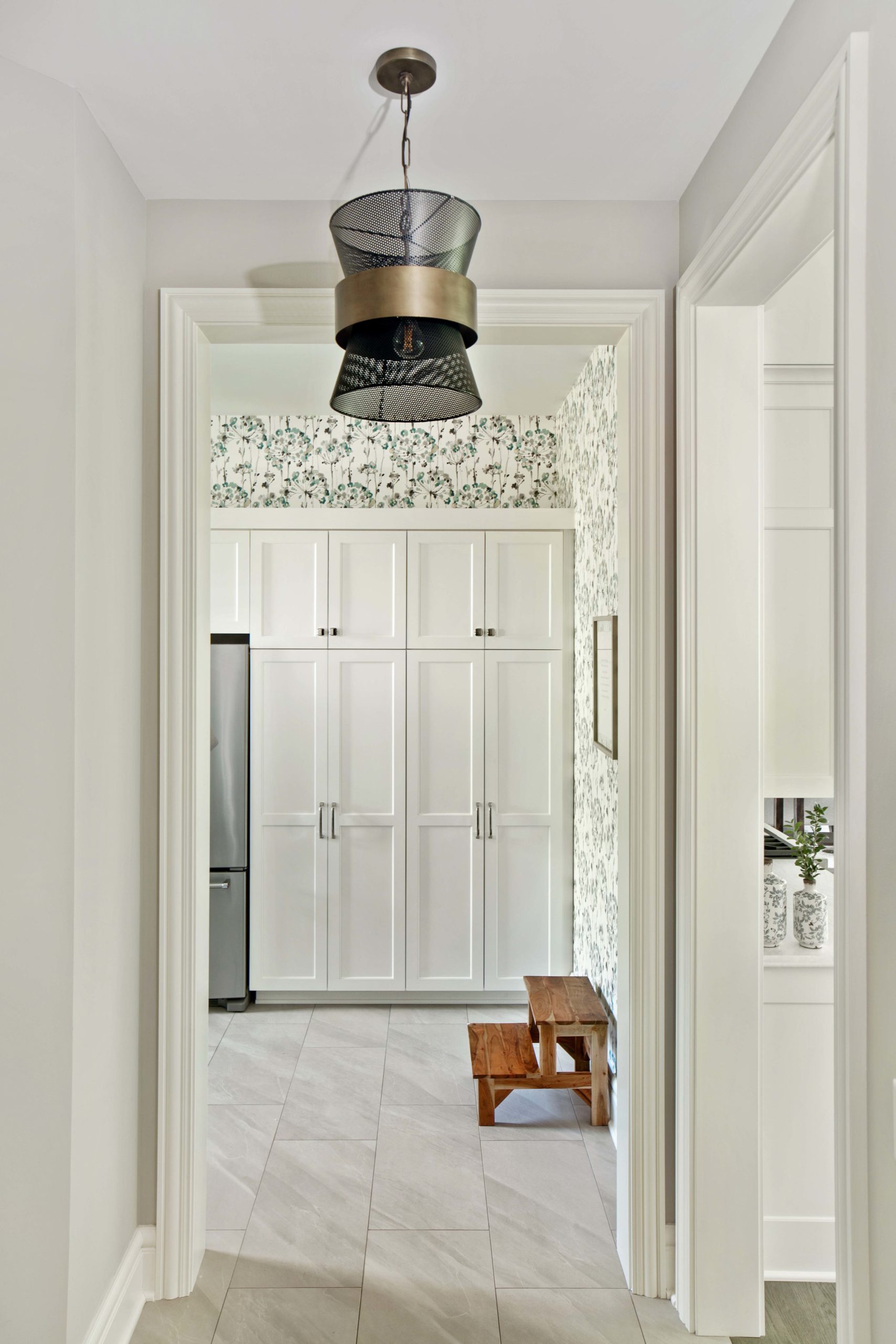 A White Oak Lane hallway adorned with white cabinets and a stunning light fixture.