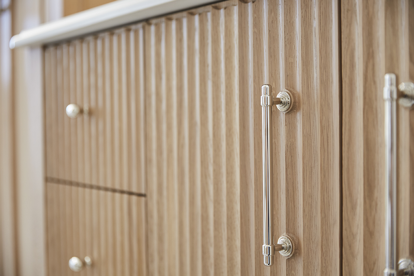 close up image of ribbed oak cabinet doors with silver pull handles
