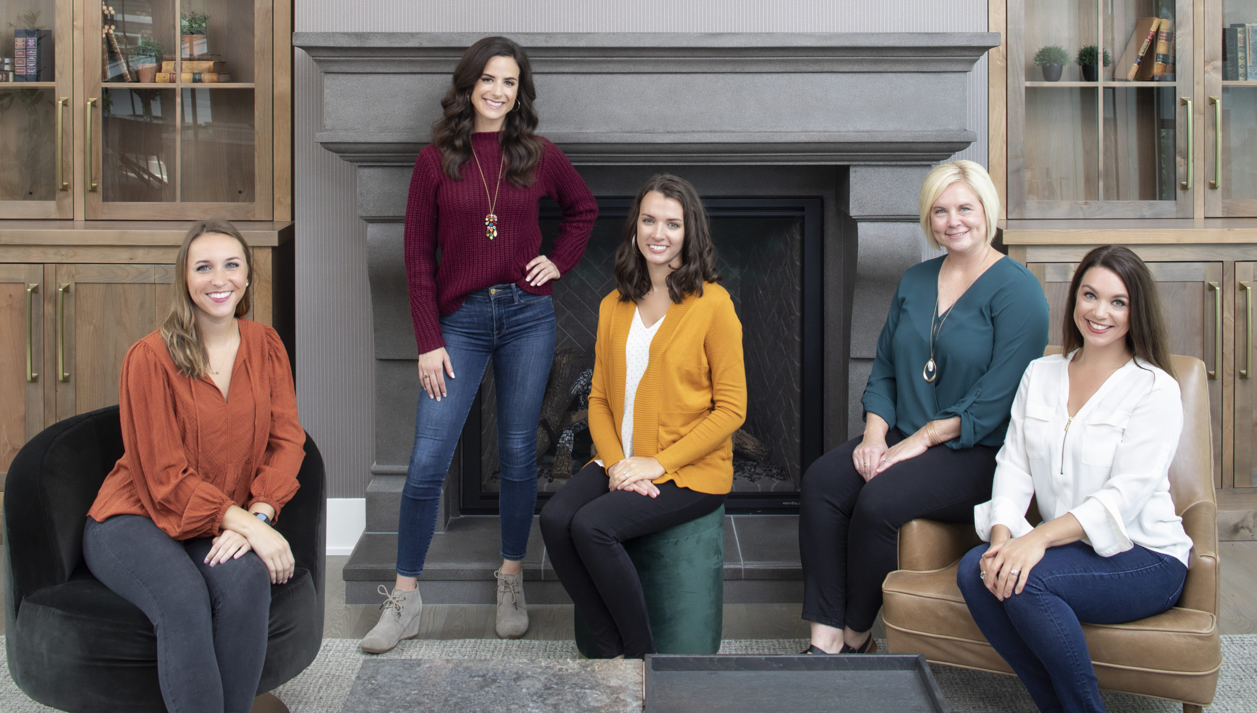 A group of women sitting in front of a fireplace at a full-service interior design studio in the Twin Cities.