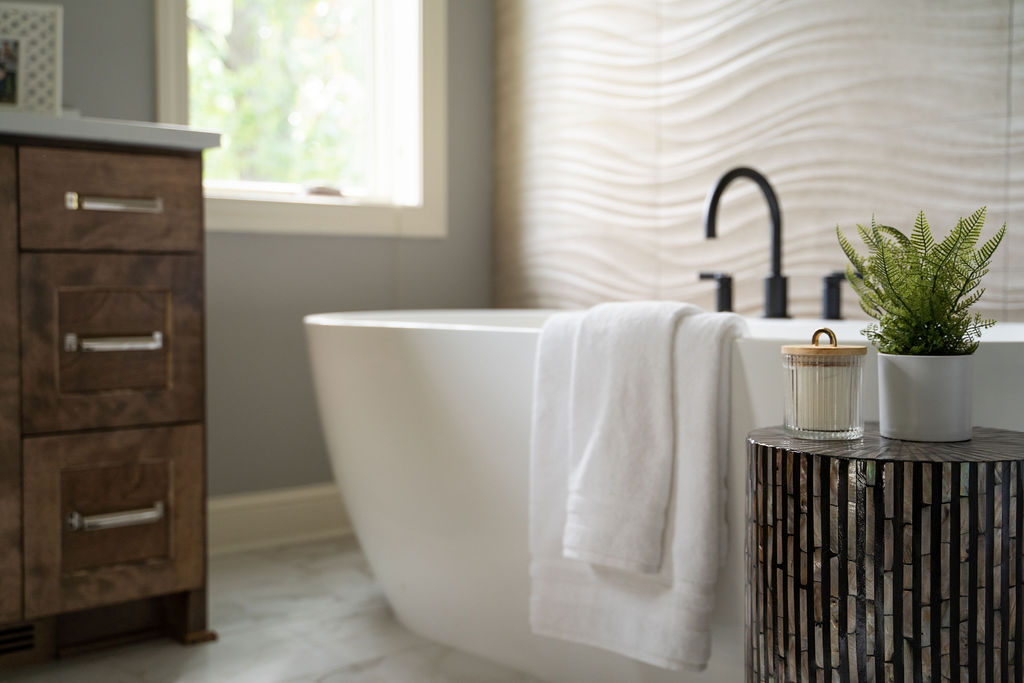 A bathroom with a tub and a plant on a table, designed as part of a Twin Cities remodeling project.