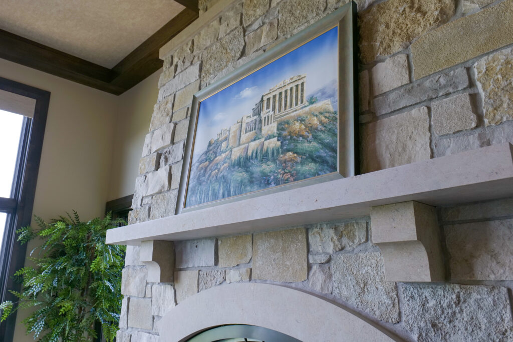 A Modern Tuscan fireplace with a painting above it.