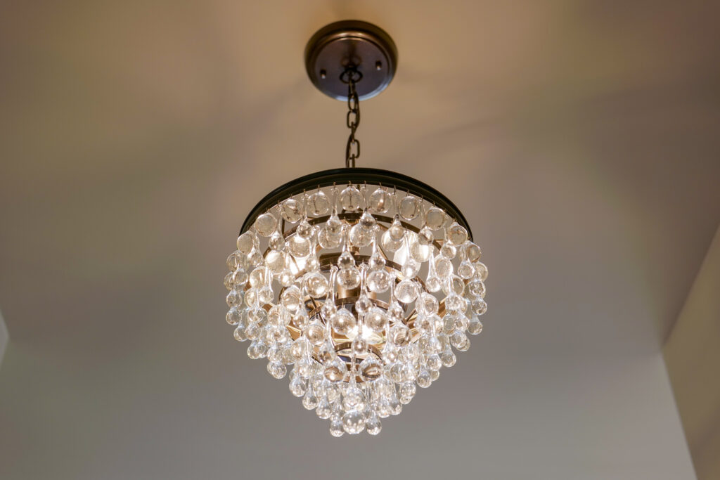 A modern chandelier adorned with crystals hanging from the ceiling.