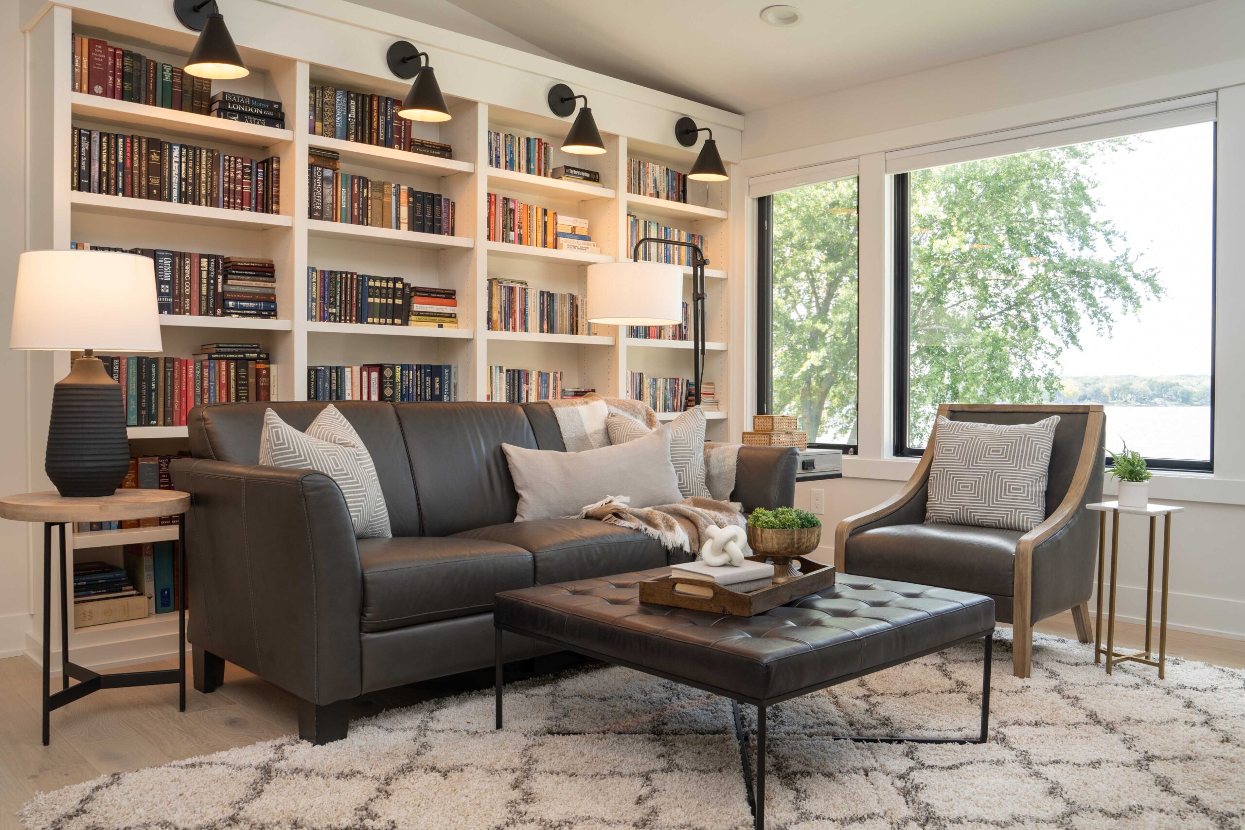 An Orchard Lake remodel with a living room featuring a couch, coffee table, and bookshelves.
