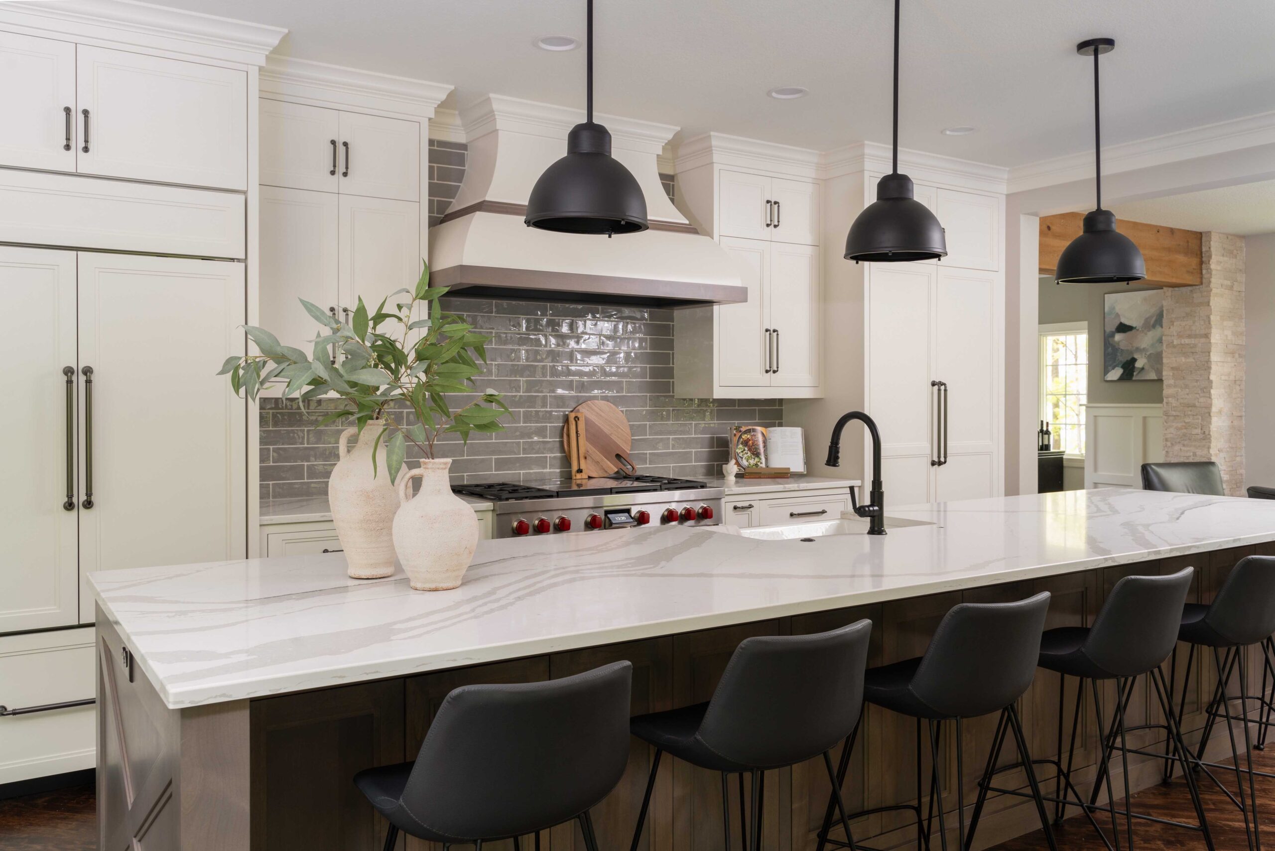 A kitchen with a center island and black stools, located on Woodside Road in Minnetonka has recently undergone a remodel.