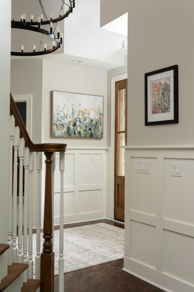 A woodside hallway with hardwood floors and a chandelier.