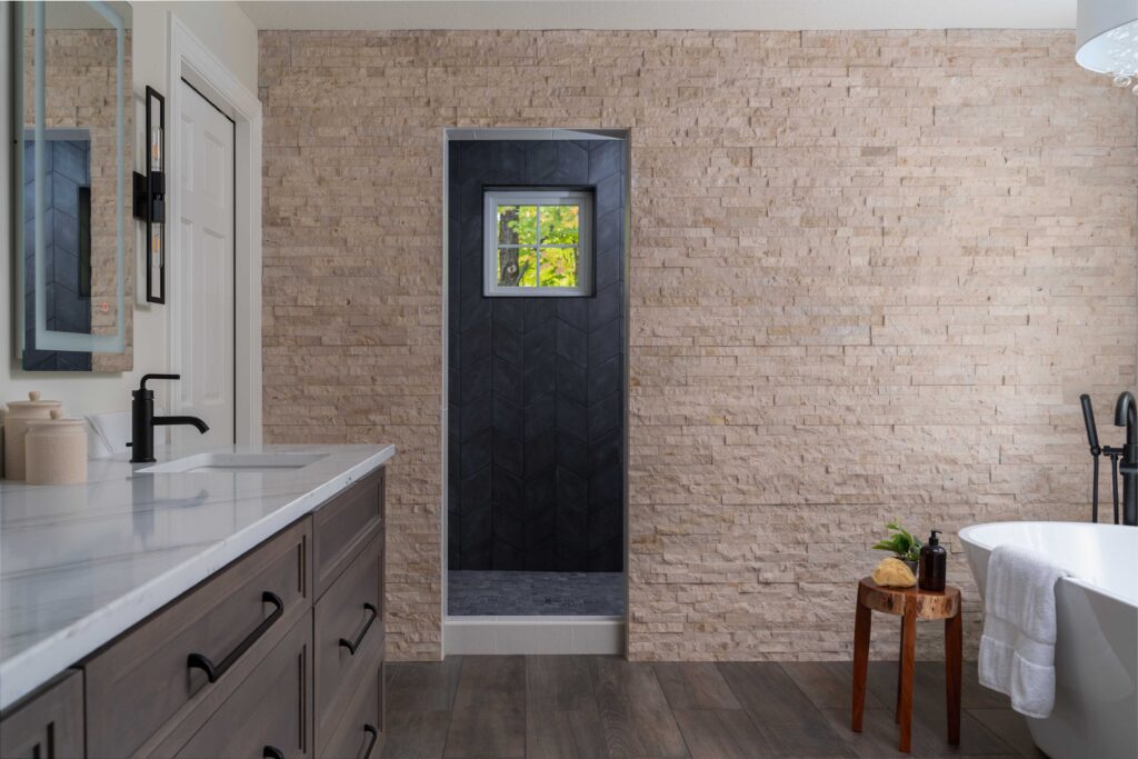 A bathroom with wood floors and a stone wall, located on Woodside Road in Minnetonka. This bathroom has undergone a remodel.