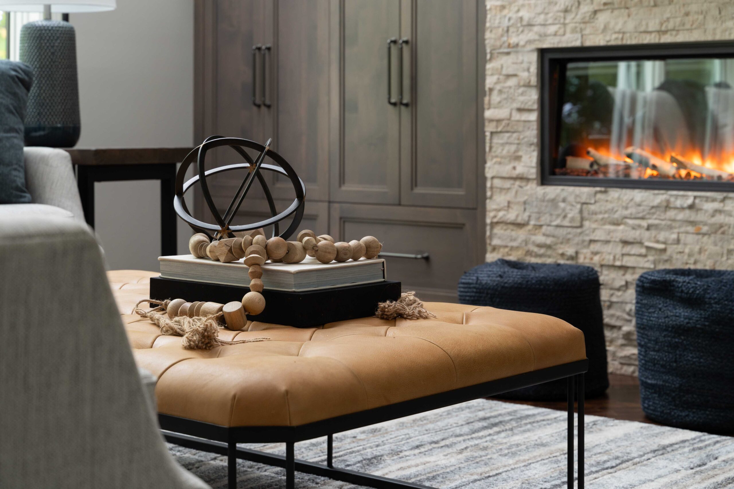 A woodside road living room remodel with a stone fireplace and ottoman in Minnetonka.